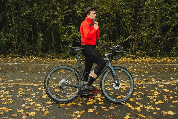 Road rider stood on the road with leaves around wearing red castelli jersey